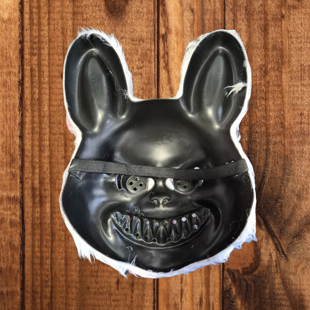 A white faux fur evil bunny mask with a blood-stained snout, yellow fangs, and floppy ears, secured with an elastic band, ideal for Halloween or cosplay