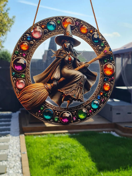 Gothic stained glass sun catcher featuring an adorable witch on a broomstick within a crescent moon adorned with bat wings and vibrant autumnal leaves. Perfect for adding a spooky yet charming touch to any window or garden decor.