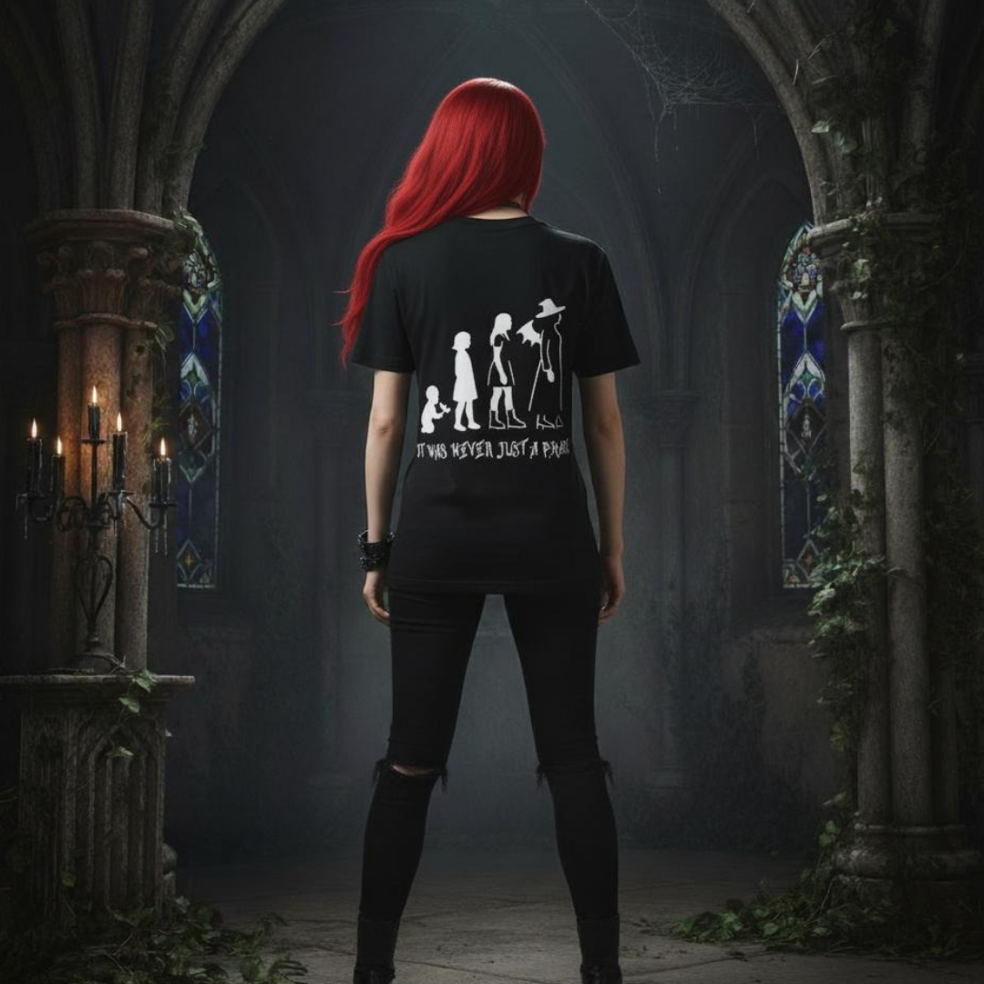 Person with red hair wearing a black t-shirt with white graphics and text in an ornate, dimly lit hallway.