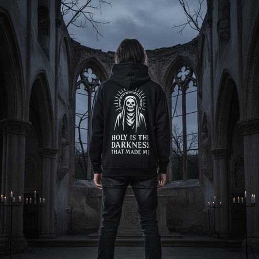 Person wearing a hoodie with a skull design and text in a dark, gothic setting.